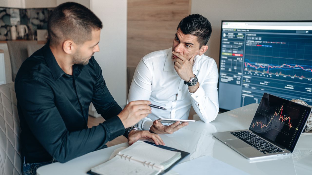 two men sitting at a table with a laptop and a tablet-Persönlichkeitstypen Verteilung der Analyst
