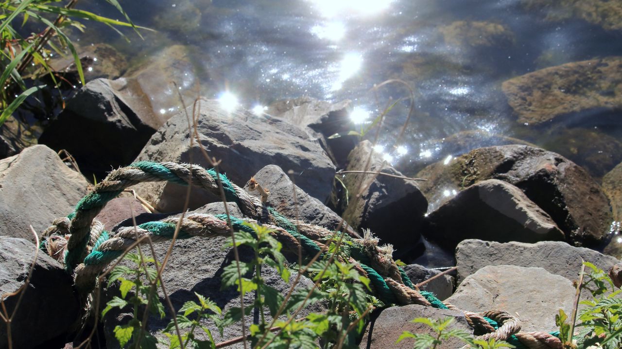ein Seil auf Felsen am Wasser-Spirituelle Transformation allte Seile Cleaning up