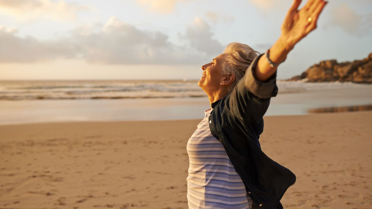 Spirituelle Transformation im Alltag - Frau am Strand mit offenen Armen
