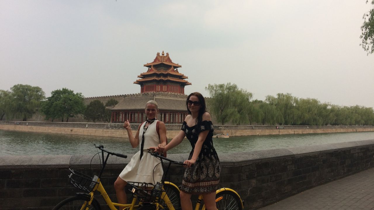 Zwei Frauen fahren Fahrrad in Peking. Chinesische Sternzeichen