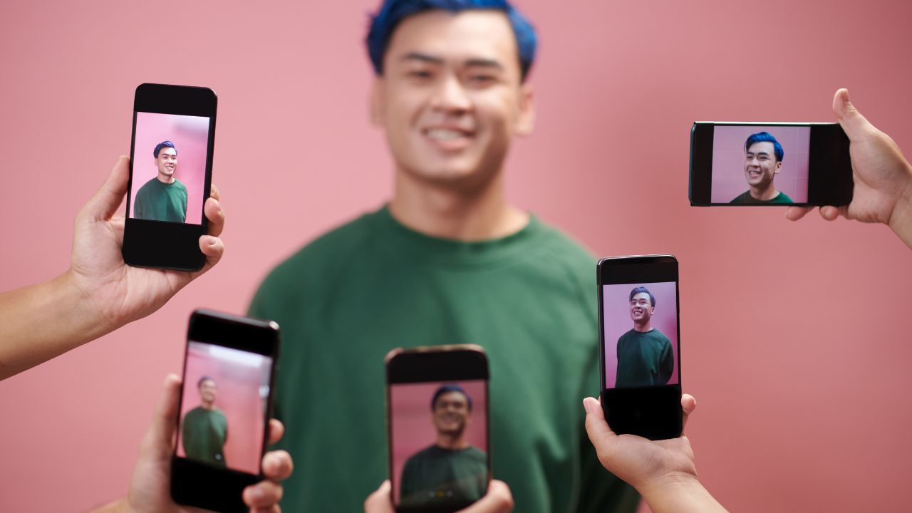 Person umgeben von Handys mit Bildern. Der narzisstische Archetyp