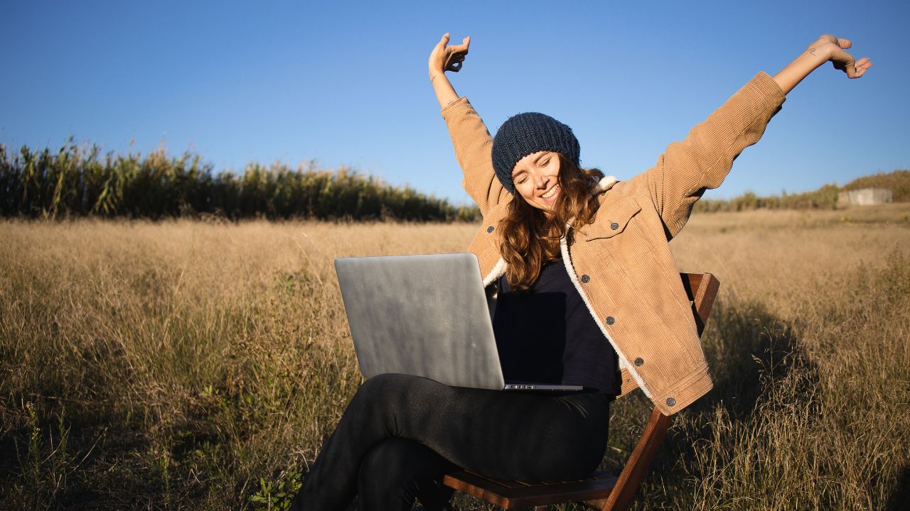 Gen Z und der Entdecker Digitale Freiheit genießen - Frau auf der Wiese mit Laptop